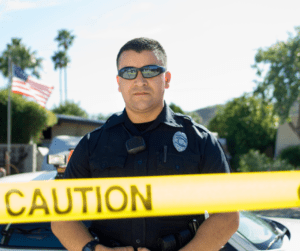 Police officer standing behind police tape