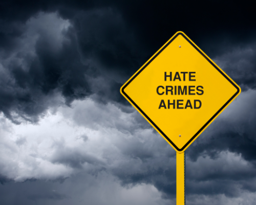 Hate Crimes Ahead Road Sign in Front of Storm Clouds